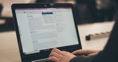 Person at Desk with Laptop Completing Resume